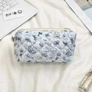 Macro detail of quilted light blue cosmetic bag featuring ocean cartoon patterns