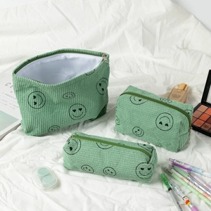 Three-piece green corduroy makeup bag set with heart-eye smiley print on white fabric