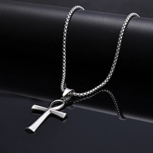 Macro shot of silver Ankh pendant with satin finish on black reflective mirror surface
