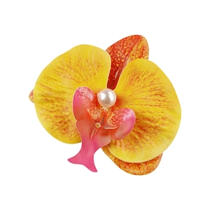 Detail of yellow and pink fabric plumeria hair clip with a centered pearl accent