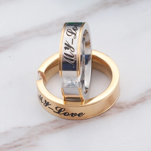 Couples stainless steel rings with My Love engraving and square zircon on marble background