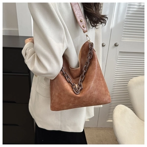 Detail of vintage brown hobo bag with thick chain strap and distressed leather texture