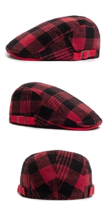 Detail view of red and black plaid wool newsboy cap with side buckle and leather strap