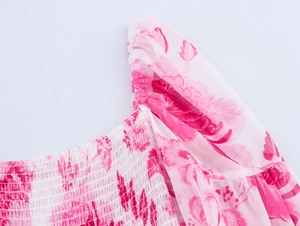 Détail du corsage froncé et du tissu en mousseline fleurie rose sur une robe à volants