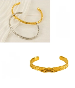 Detail of irregular lava texture on gold and silver stainless steel cuff bangles