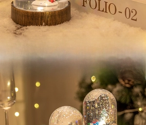 Macro detail of Christmas snow globe with snowman, glitter flakes and wood texture base