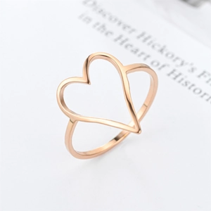 Detailed close-up of a rose gold hollow heart ring on a minimalist book background