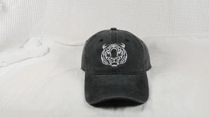 Close-up of white tiger head embroidery on a vintage washed cotton black baseball cap