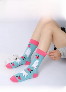 Close-up of sky blue cotton crew socks featuring polar bear and rose knitted patterns