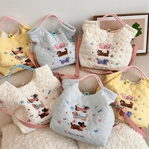 Detail of cute cartoon animal embroidery and heart quilted fabric on soft tote bags