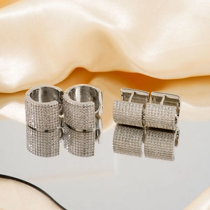 Luxurious silver hoop earrings with micro-paved zircons on elegant champagne silk fabric