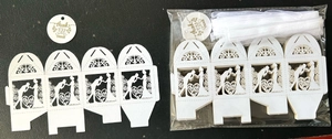 Detail of laser-cut wedding favor box with bride and groom silhouette and ribbon