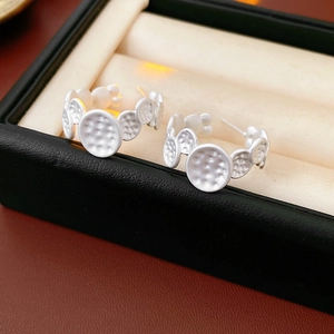 Vue macro de boucles d'oreilles rondes irrégulières blanches avec une surface texturée