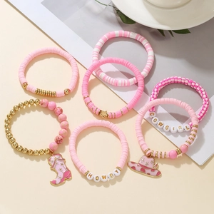 Detail of pink cowgirl themed bracelet set with clay beads and Western style charms