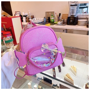 Girl holding pink sequin heart backpack with bow and glitter transparent pocket details