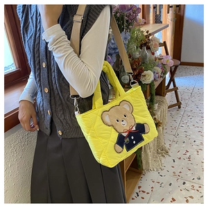 Detail of yellow quilted crossbody bag for kids with cute teddy bear embroidery patch