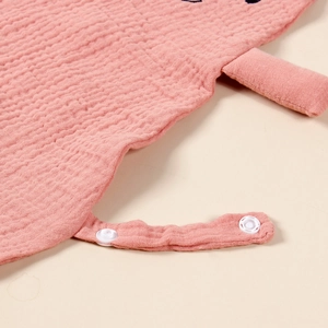 Detail of pink cotton muslin baby comforter showing the soft texture and white snap buttons