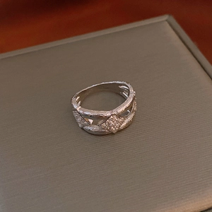 Detail of silver bow ring with hollow geometric lines and micro-pave cubic zirconia