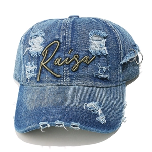 Detail of washed denim baseball cap with Raisa embroidery and silver metal rings