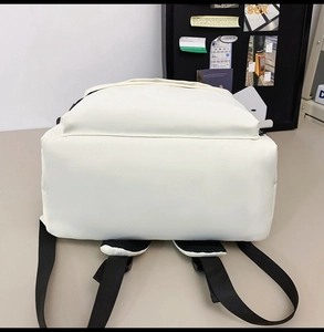 Detailed bottom view of an off-white backpack featuring black breathable mesh straps