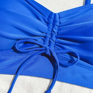 Close-up of royal blue ruched bikini top featuring ribbed texture and front tie detail
