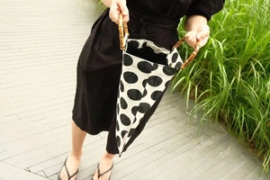 Detail of vintage polka dot tote bag with authentic bamboo circular handles in outdoor light