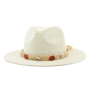 Detail of woven straw sun hat featuring decorative sea shells and tassel embellishments