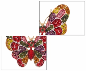 Macro detail of butterfly brooch showing colorful rhinestones and red teardrop crystal