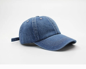 Close-up of the blue denim fabric texture and stitching on a curved brim baseball cap