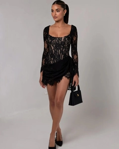 Détail de mini-robe noire en dentelle à manches longues avec corsage et maille fine