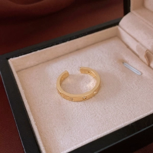 Close-up of gold star engraved ring with zircon stones in a velvet jewelry gift box