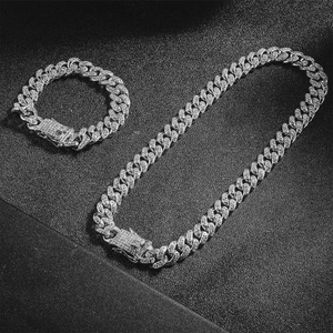 Detailed view of silver men's Cuban link chain and bracelet set with sparkling rhinestones