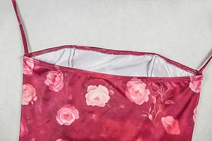Dettaglio della stampa a rose rosso scuro e delle sottili spalline dell'abito
