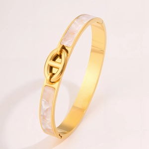 Detail of gold titanium bracelet with white mother of pearl inlay and pig nose anchor link