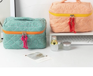Detail of quilted plaid cosmetic bags in green and orange with vibrant tassel zippers