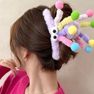 Detail of purple plush monster hair claw clip with colorful antennae on a model's hair