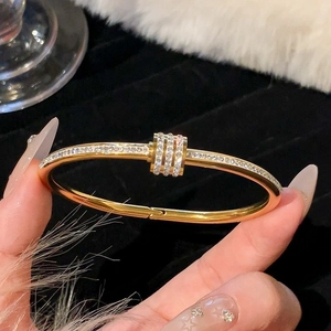 Elegante bracciale in acciaio al titanio dorato con diamanti scintillanti dal design di lusso