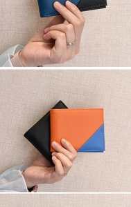 Detail view of bi-fold wallets showing black and color-block leather texture design