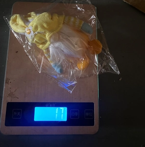 Detalle de gnomo de peluche amarillo con medición de peso de 17g para Pascua
