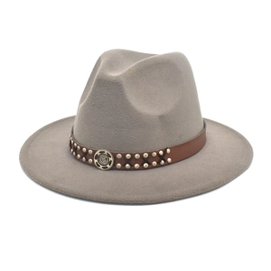 Detail of gray felt fedora hat featuring brown leather band with metal rivets and gear emblem
