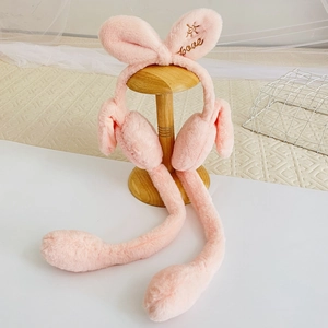 Macro view of pink plush earmuffs with embroidered Love lettering and long air pump tubes