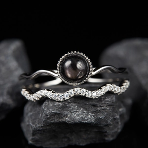 Macro shot of S925 silver ring set with natural gemstone on textured dark rock surface