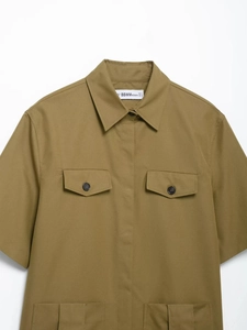 Close-up of khaki short sleeve utility shirt showing chest pocket and twill texture