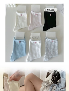Detailed close-up of six-color pastel cotton socks with decorative pink shell buttons