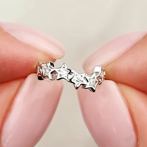 Macro shot of silver star-shaped ear cuff with pave-set sparkling cubic zirconia