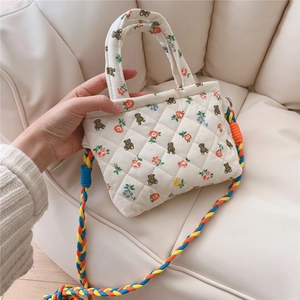 Close-up of quilted floral crossbody bag with bear prints and colorful woven strap