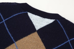 Detail view of navy blue diamond pattern knit sweater showing rib neckline texture