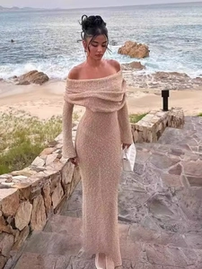 Elegant champagne off-shoulder long sleeve maxi dress with shimmering fabric on beach
