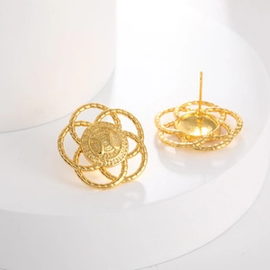 Detailed macro view of gold-finished titanium stud earrings with interlocking ring design
