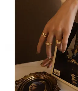 Close-up of gold stainless steel multi-layer crossover ring worn on a finger